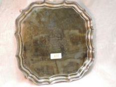 A silver salver having raised pie crust rim, hoof feet and presentation inscription to centre,