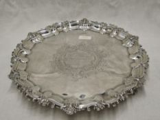 An Edwardian silver salver having moulded raised pie crust rim, trefoil bracket feet and central