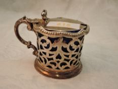 A Victorian silver lidded mustard pot having pierced decoration, moulded bow thumb rest and blue