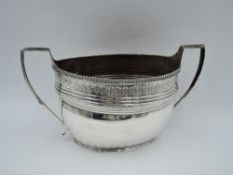 A large Georgian silver sugar bowl of oval form having engraved decoration, gadrooned rim and