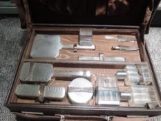 A 1940's brown leather travel case bearing monogram M.G containing an inner dressing case fitted