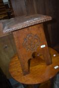 An Arts and Crafts stool, having carved detail and tooled leather top, probably Liberty's