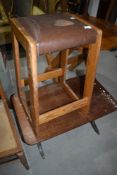 A vintage pine stool with leather top and a stained frame coffee table