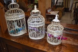 A set of three ornamental bird cages, graduated sizes