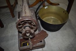 A vintage brass jam pan and hand crank sewing machine