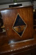 An Arts and Crafts dark oak smokers cabinet