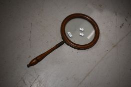 A 19th Century mahogany framed over sized looking glass having turned handle, diameter approx. 26cm