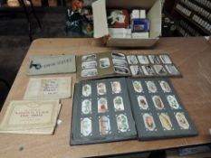 A box of Cigarette Cards in albums and loose including Wills, Players, Senior Service etc