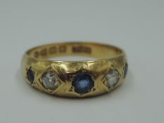 A Victorian 18ct gold band ring having three powder blue sapphires interspersed by two diamonds,