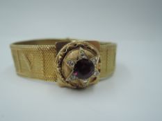 A plaited yellow metal slide bracelet nearing word SOUVENIR in plaiting having decorative clasp