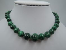 A string of graduated malachite beads having glass spacers and barrel clasp, approx 20'