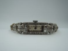 A white metal cocktail watch having an Arabic numeral dial to rectangular face in a diamond