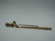 A yellow metal stick pin in the form of a golf club bearing an inset diamond in the club head, no
