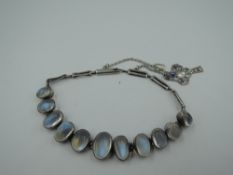 A moonstone bracelet having eleven graduated cabouchons in collared white metal mounts on a gate