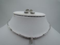 A white metal articulated bar link necklace having four channel set diamond bars with a central
