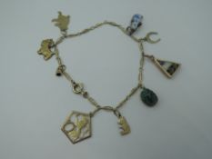 A yellow metal fancy link bracelet bearing continental marks, having eight charms including Dutch