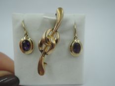 A pair of 9ct gold drop loop earrings having oval heat treated amethysts and a yellow metal knot bar