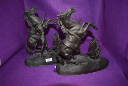 A pair of spelter or similar horses with semi nude handlers.