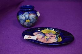 Two ceramics by Moorcroft in deep blue glazes a trinket dish and matching vase