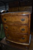A reproduction walnut dwarf chest of three bow fronted drawers