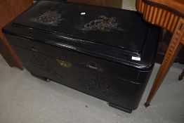 An Oriental style ebonised camphorwood blanket box , raised on shepherds style castors