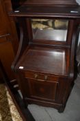 An Edwardian mahogany and inlaid coal purdonium having mirror back