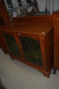 A traditional golden oak sideboard/cabinet in the Arts and Crafts style, having coloured and