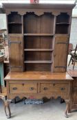 An oak dresser, the rack with a moulded cornice above shelves and cupboards,