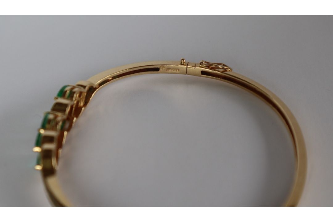 A 14ct yellow gold emerald and diamond set hinged bangle, - Image 3 of 4