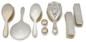 A George V engine turned silver backed five piece dressing table set; others