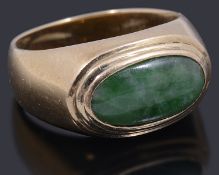A gold single stone cabochon jade ring