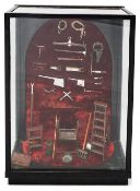 An unusual display case containing a selection of butchers tools in miniature c.1900