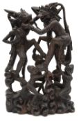 A 20th century Balinese hardwood carving depicting monkeys engaged in battle,