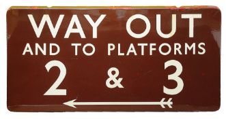 A BR(M) enamel sign displaying 'WAY OUT / AND TO PLATFORMS / 2 & 3',with white lettering on a maroon