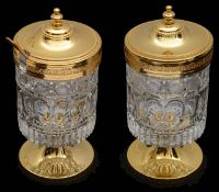 A pair of continental gilt metal and moulded crystal preserve pots and covers, (2)