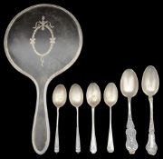 A George V silver mounted tortoiseshell hand mirror and various silver spoons.