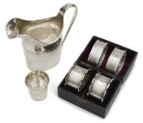 An Edwardian silver helmet shaped cream jug, a cased pair of Vict. napkin rings and other items