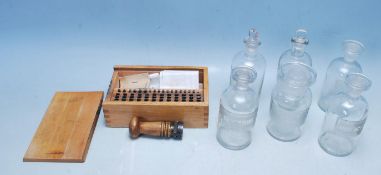 EARLY 20TH CENTURY EDWARDIAN POST OFFICE METAL STAMPERS AND SIX CHEMISTRY GLASS BOTTLES