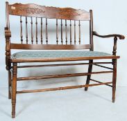 AN EDWARDIAN EARLY 20TH CENTURY OAK LOVESEAT