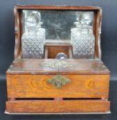 EARLY 20TH CENTURY OAK TANTALUS WITH GLASS DECANTERS