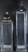 GRADUATING PAIR OF POLISHED METAL AND GLASS LANTERNS