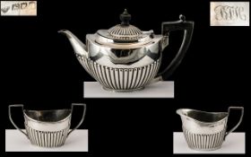 Small Silver Three Piece Harlequin Bachelor Tea Set, with embossed, fluted bodies and ebony handles;