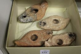 Four early pottery oil lamps.
