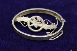 A silver bangles and a silver brooch.