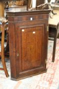 A George III oak hanging corner cupboard.