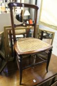 A Victorian cane seated chair and a gilt framed dressing table mirror.