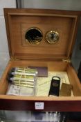 A Dupont lighter with accessories and a humidor.