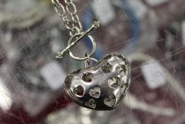 A necklace with pierced heart shaped pendant.