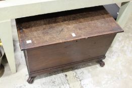 A mahogany trunk on carved feet.