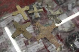 A collection of small bronze crosses.